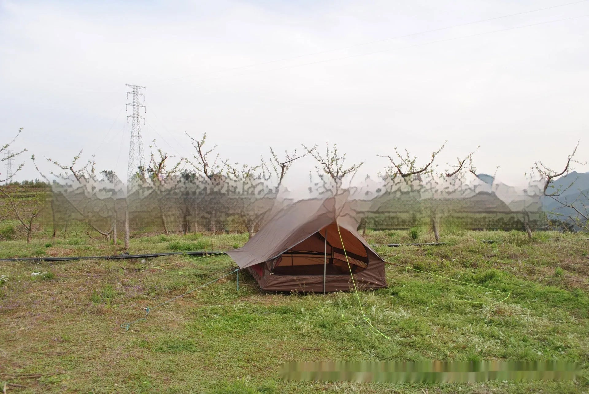 Brown and white pole-free A-line cabin tent for 2-3 people shown pitched with hiking poles.