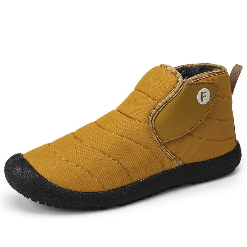 Men's thick black waterproof snow boots with a rubber sole on a hard surface.