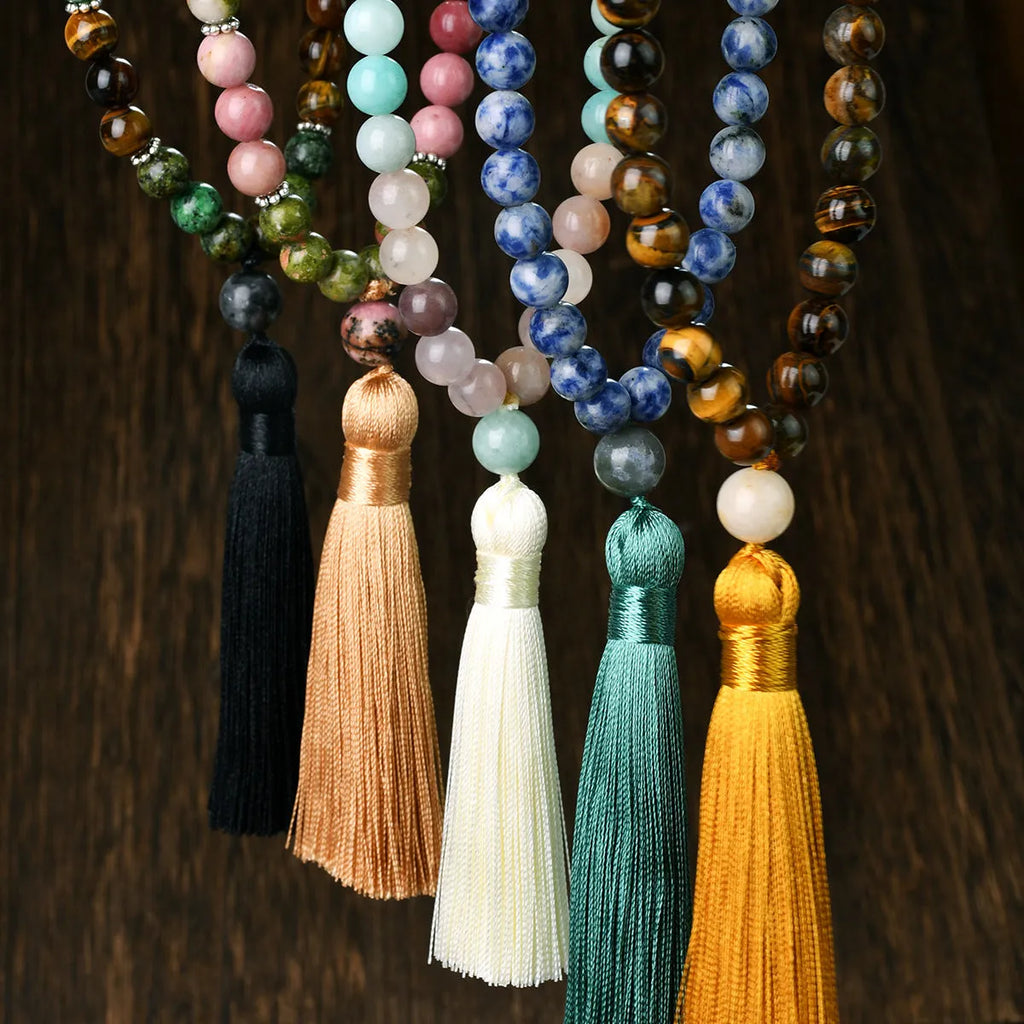 A long bohemian-style necklace with a geometric mixed gemstone pendant and a coloured tassel on a ball bead chain.