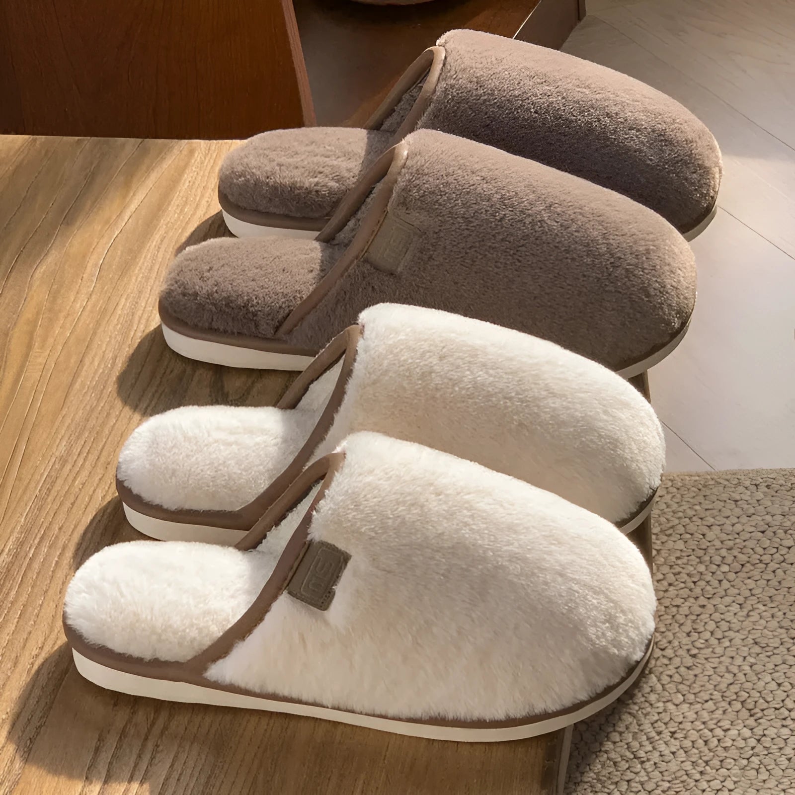 A pair of solid blue plush slip-on house slippers with a non-slip PVC sole and decorative car stitching on the upper.