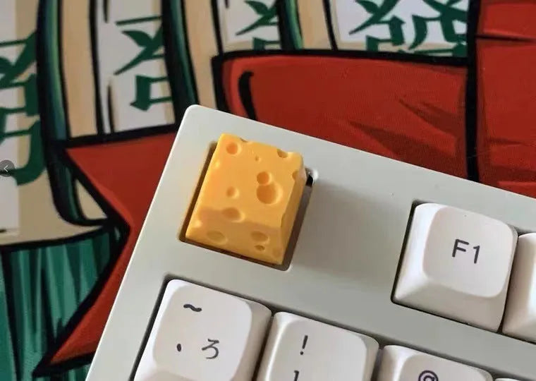 Yellow resin cheese character key cap for mechanical keyboards on a white background.