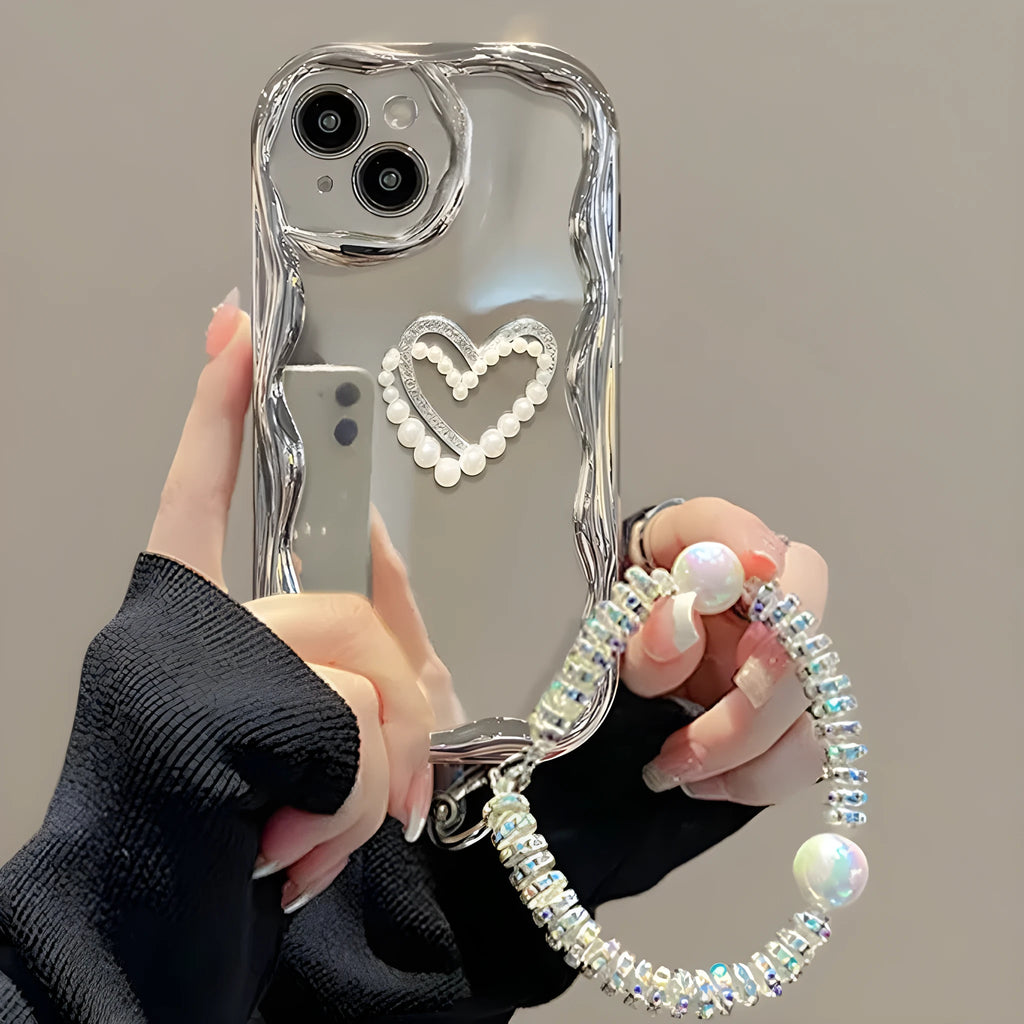 Silver grey silicone phone case for iPhone 14 Pro Max with three-dimensional heart and pearl chain bracelet.
