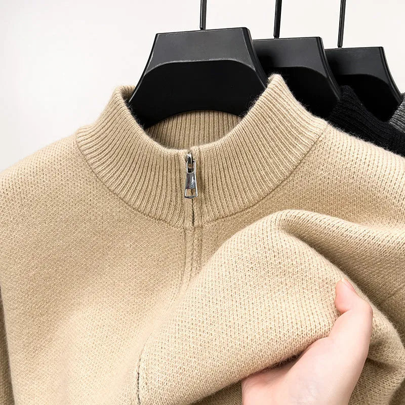 Man wearing a thick grey stand collar knitted cardigan with a zipper front.