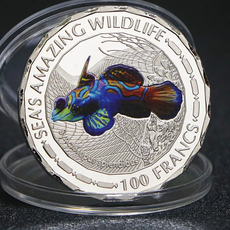 Set of eight silver plated commemorative coins with tropical fish and marine animal designs, 40mm diameter, in acrylic box