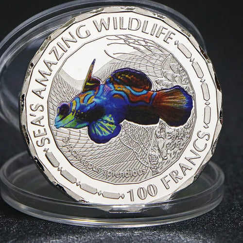 Set of eight silver plated commemorative coins with tropical fish and marine animal designs, 40mm diameter, in acrylic box