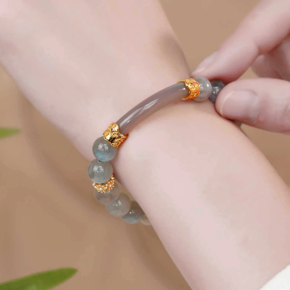 Grey moonstone women's bracelet with 8mm round beads on a wrist.