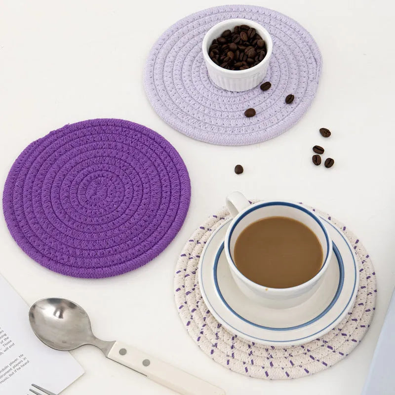 Three round cotton cord coasters in blue, measuring 18cm diameter, on wooden table