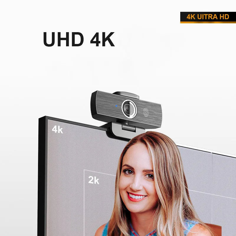 Black 4K USB webcam with auto focus on a desktop, shown with its magnetic privacy cover.
