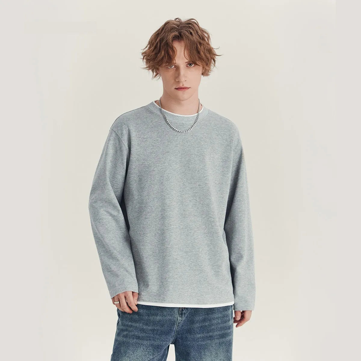 Man wearing a loose grey long-sleeved cotton blend T-shirt with a round neck.