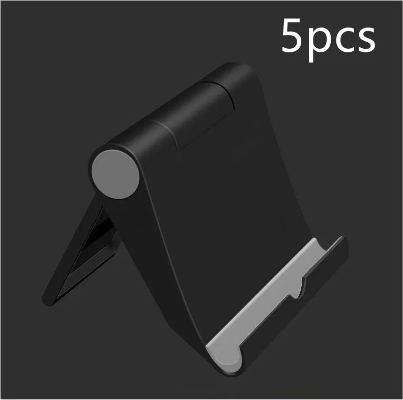 Black PE folding tablet stand holding a mobile phone at an adjustable viewing angle on a wooden desk.