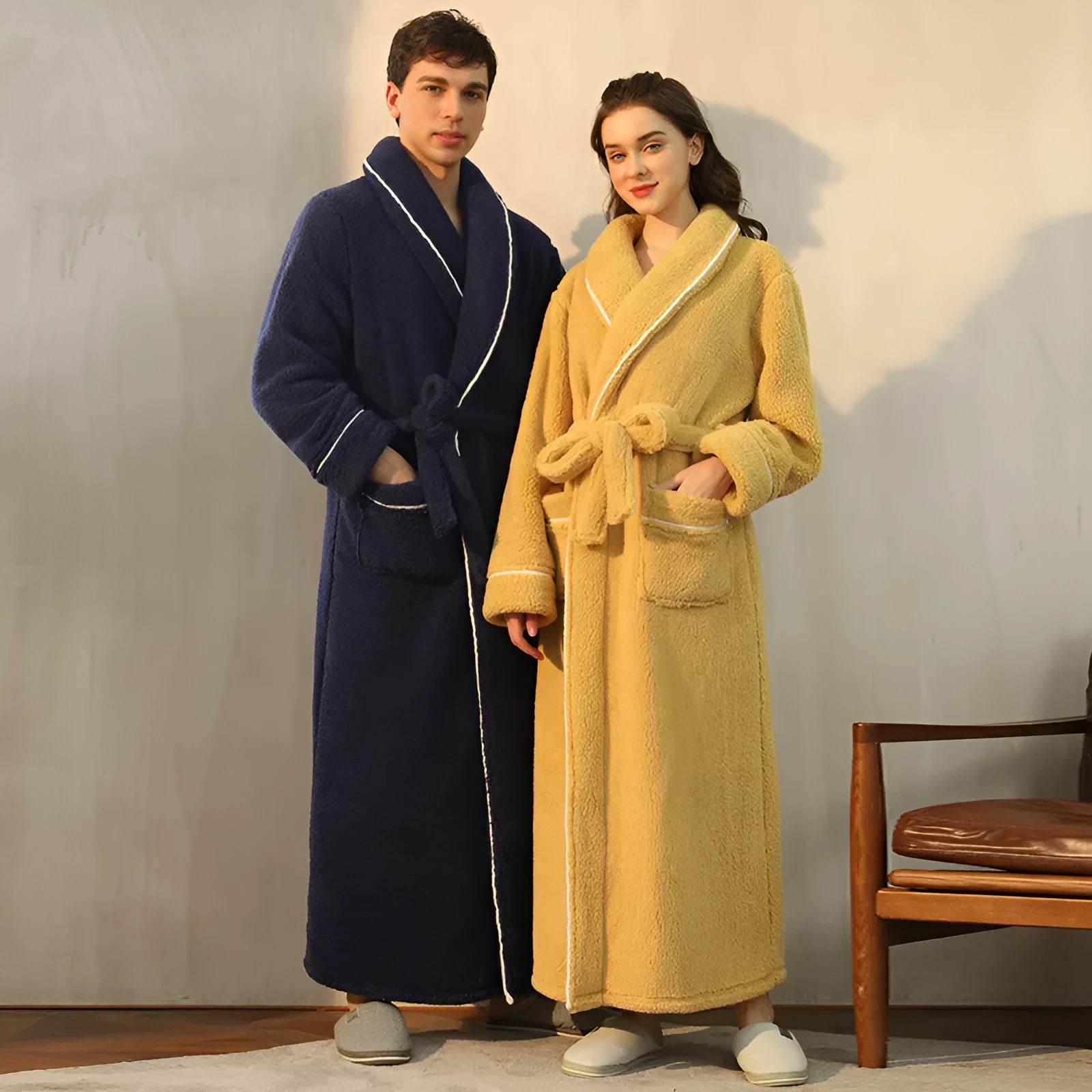 A man and woman wearing matching thick, navy blue flannel bathrobes in a European style cut.