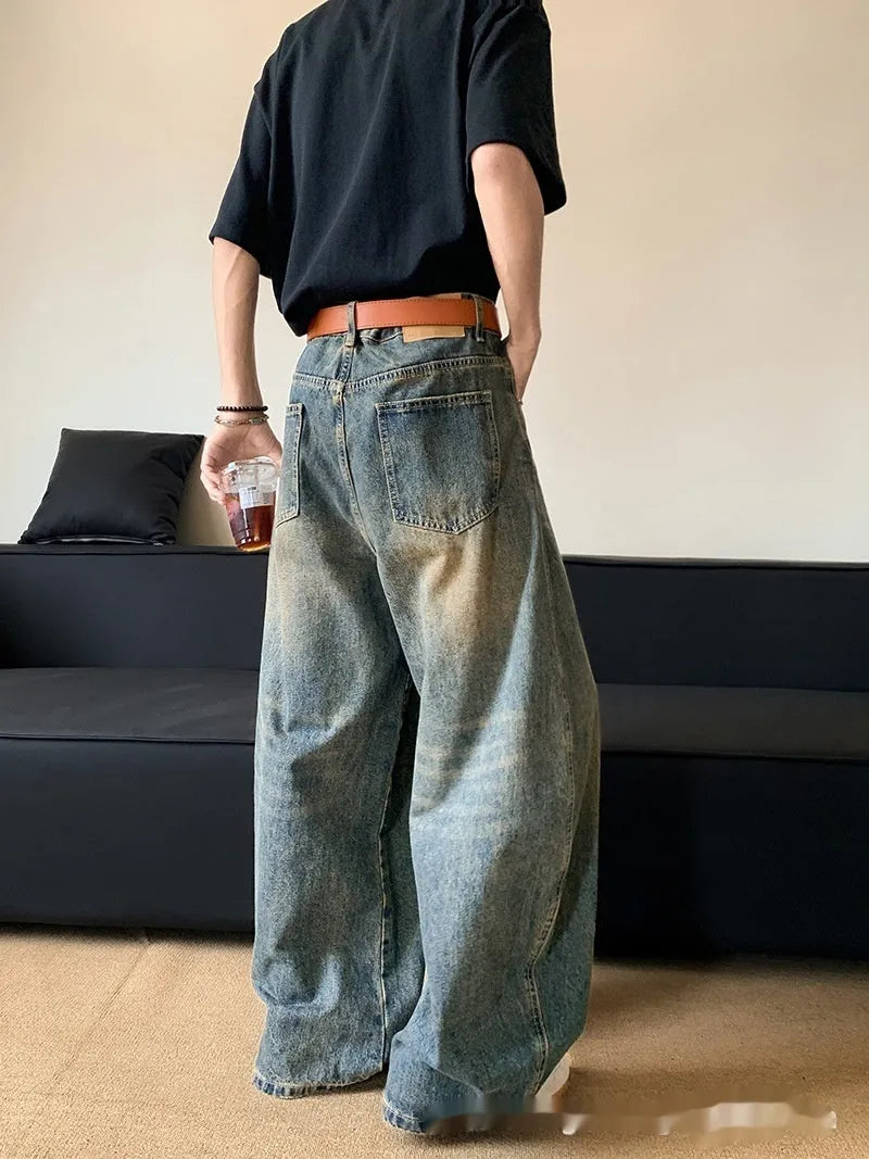 Man wearing Retro Blue distressed wide-leg denim jeans with a slimming silhouette and mid-waist fit.