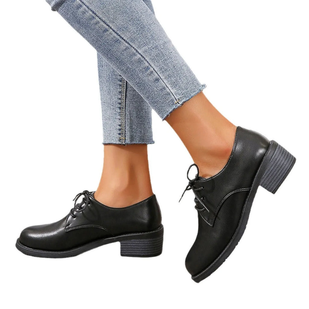 Black women's low-top work shoes with a chunky rubber heel and PU leather upper