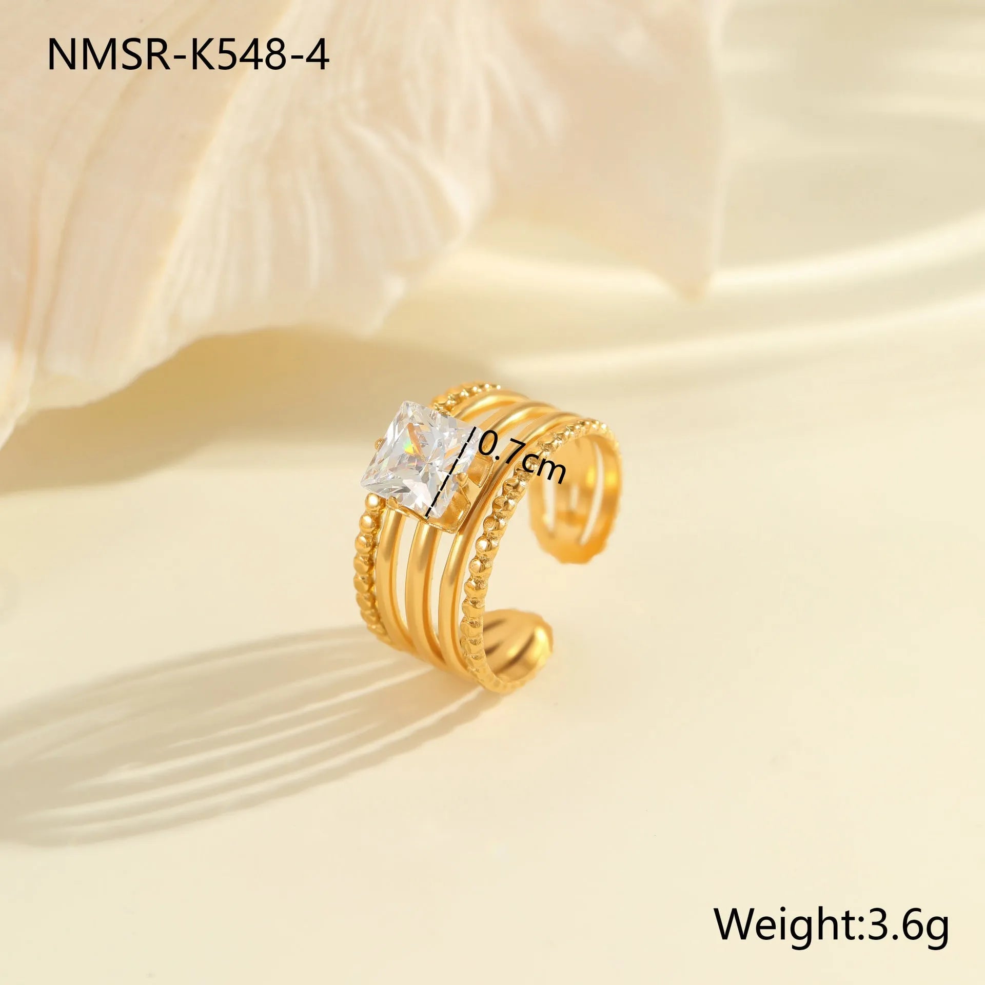Gold electroplated adjustable ring with geometric zircon design on a stainless steel band.