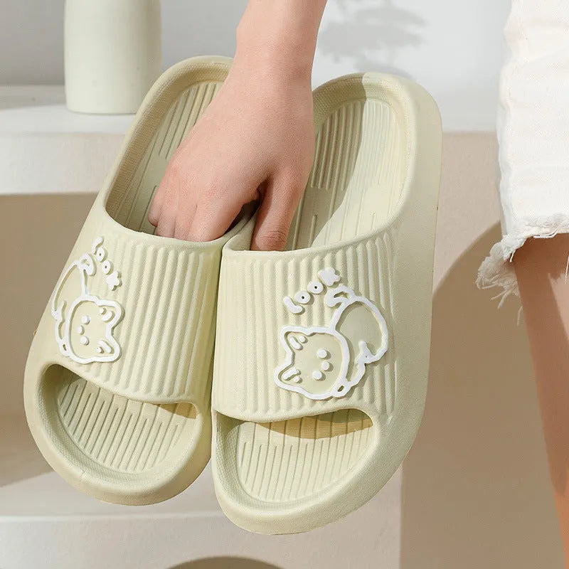 Women's pink EVA cat slippers with thick platform sole on a wooden floor.