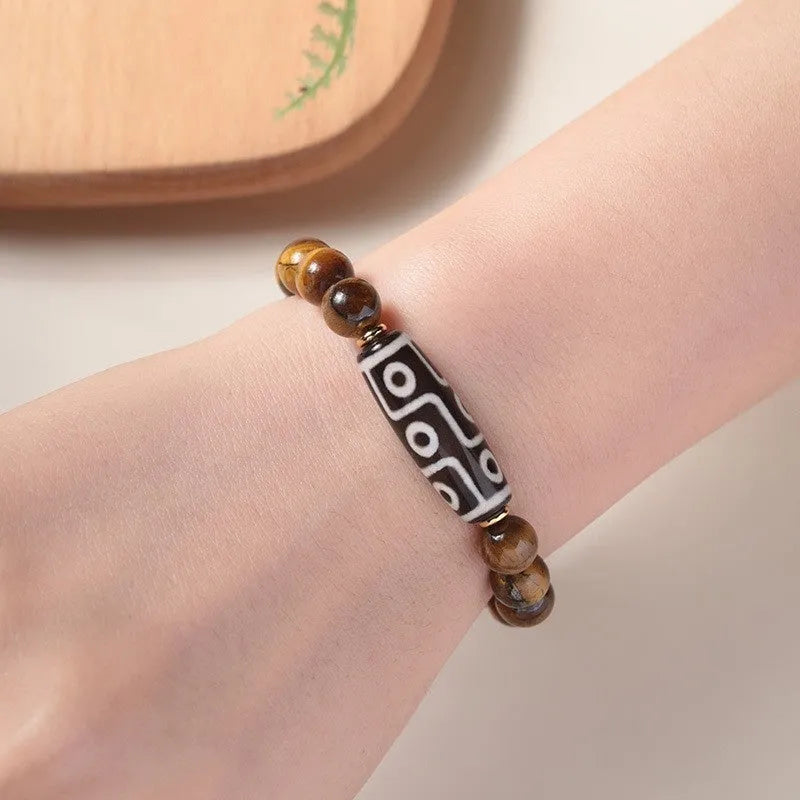 Single circle ethnic Tigereye bead Buddha rosary bracelet on a wrist, showing unisex design.