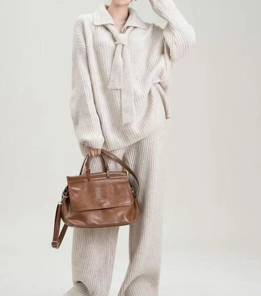 Beige women's acrylic knit top and trouser two-piece set laid flat, showing collage stitching detail on the fabric.