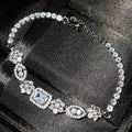 Women's geometric silver bracelet with inlaid zircon stones on a wrist, showing adjustable chain.
