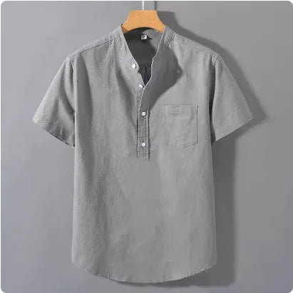 Man wearing a beige slub linen casual shirt with a stand collar and short sleeves.
