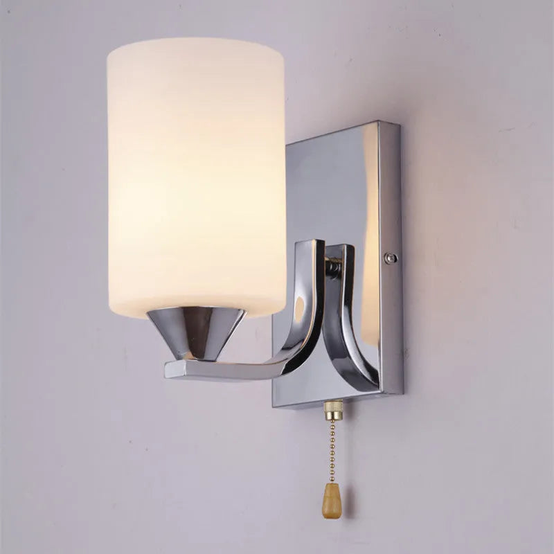 A modern chrome wall lamp with a clear glass shade, shown in single-head and double-head styles.