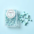 Plastic push pins in cherry blossom pink, mint green, and lavender colours, showing both large and small sizes on a white surface