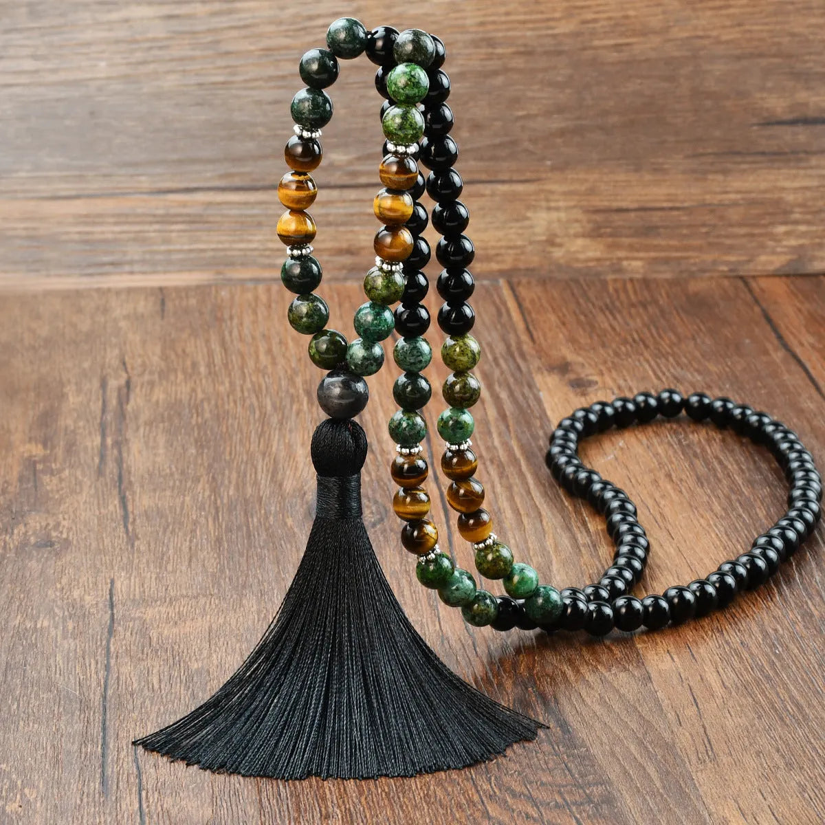 A long bohemian-style necklace with a geometric mixed gemstone pendant and a coloured tassel on a ball bead chain.