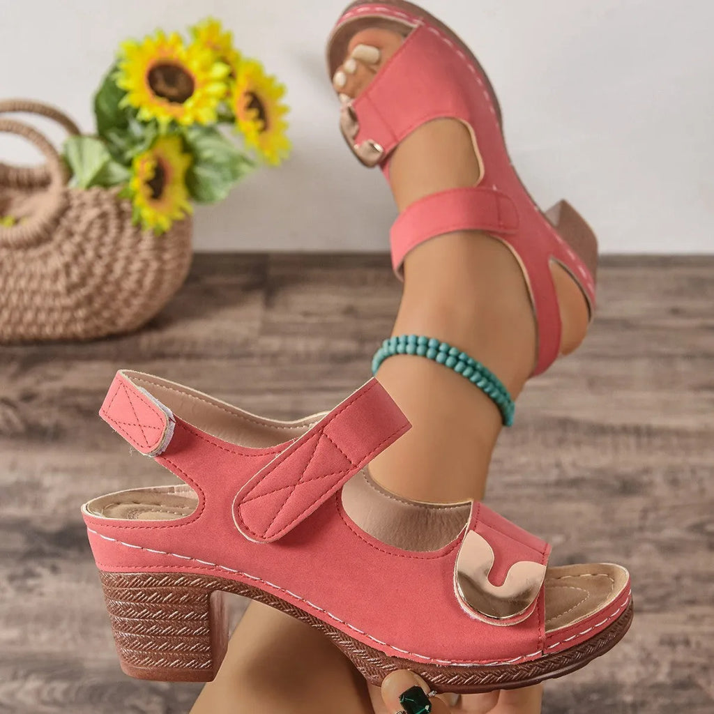 A pair of light brown Roman-style sandals with a round toe and a single adjustable Velcro strap across the instep.