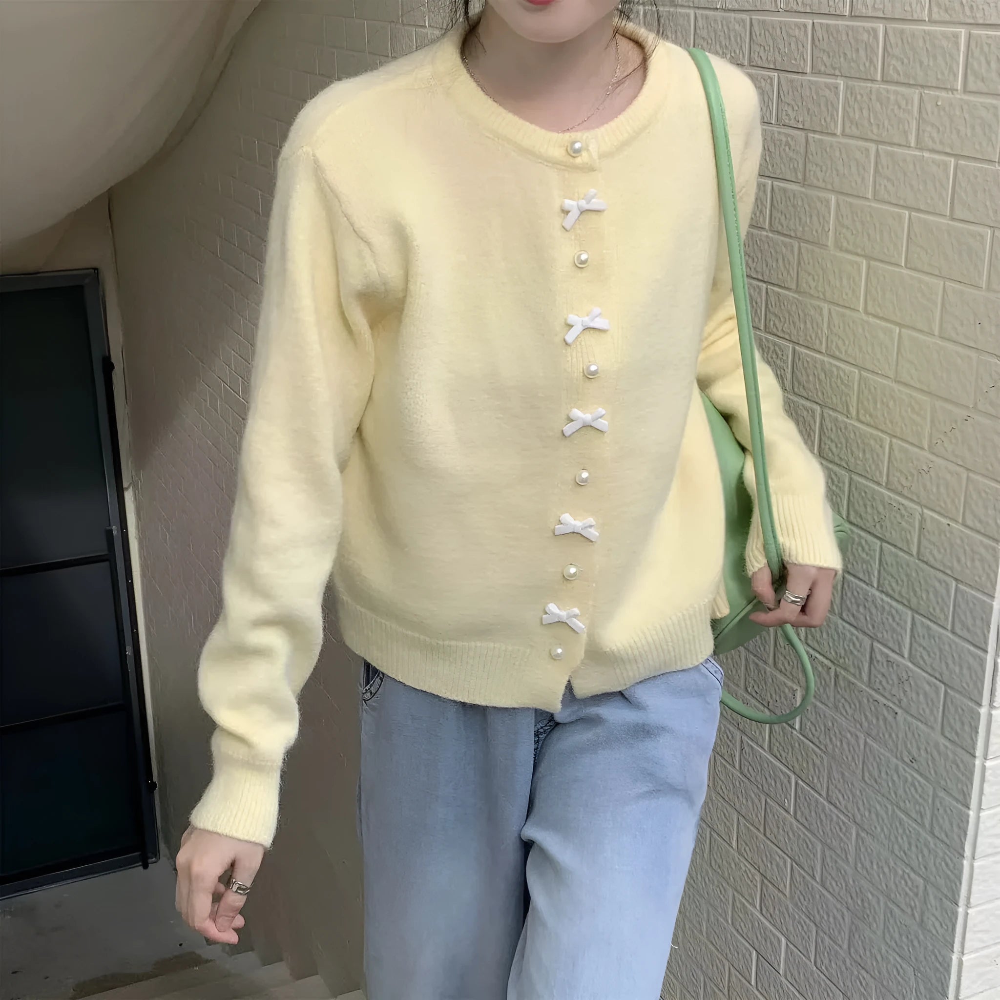 Women's cashmere cardigan sweater with bow accent and pearl buttons in nine colour options