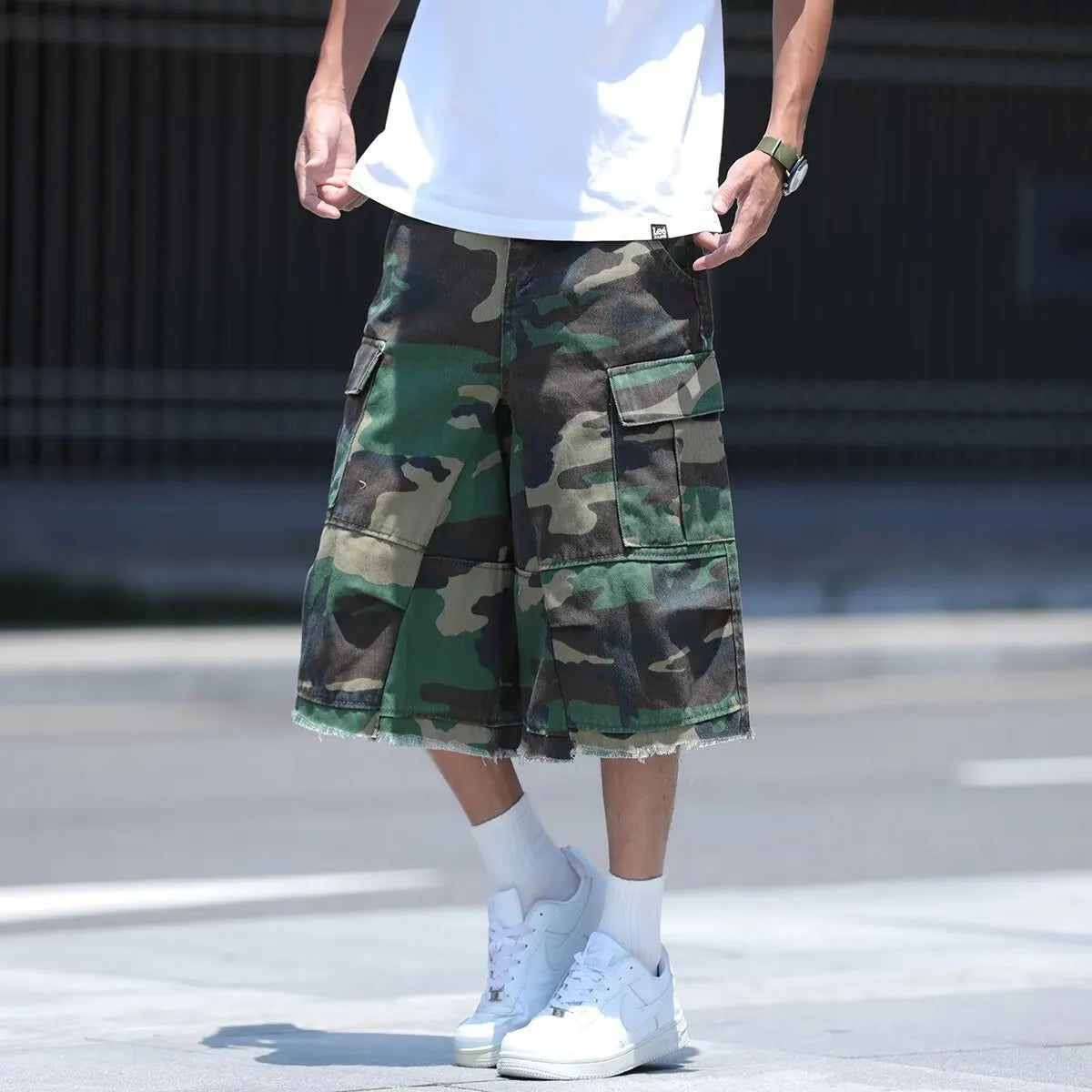 Man wearing loose, cropped camouflage shorts in a khaki colourway, showcasing the summer workwear style.