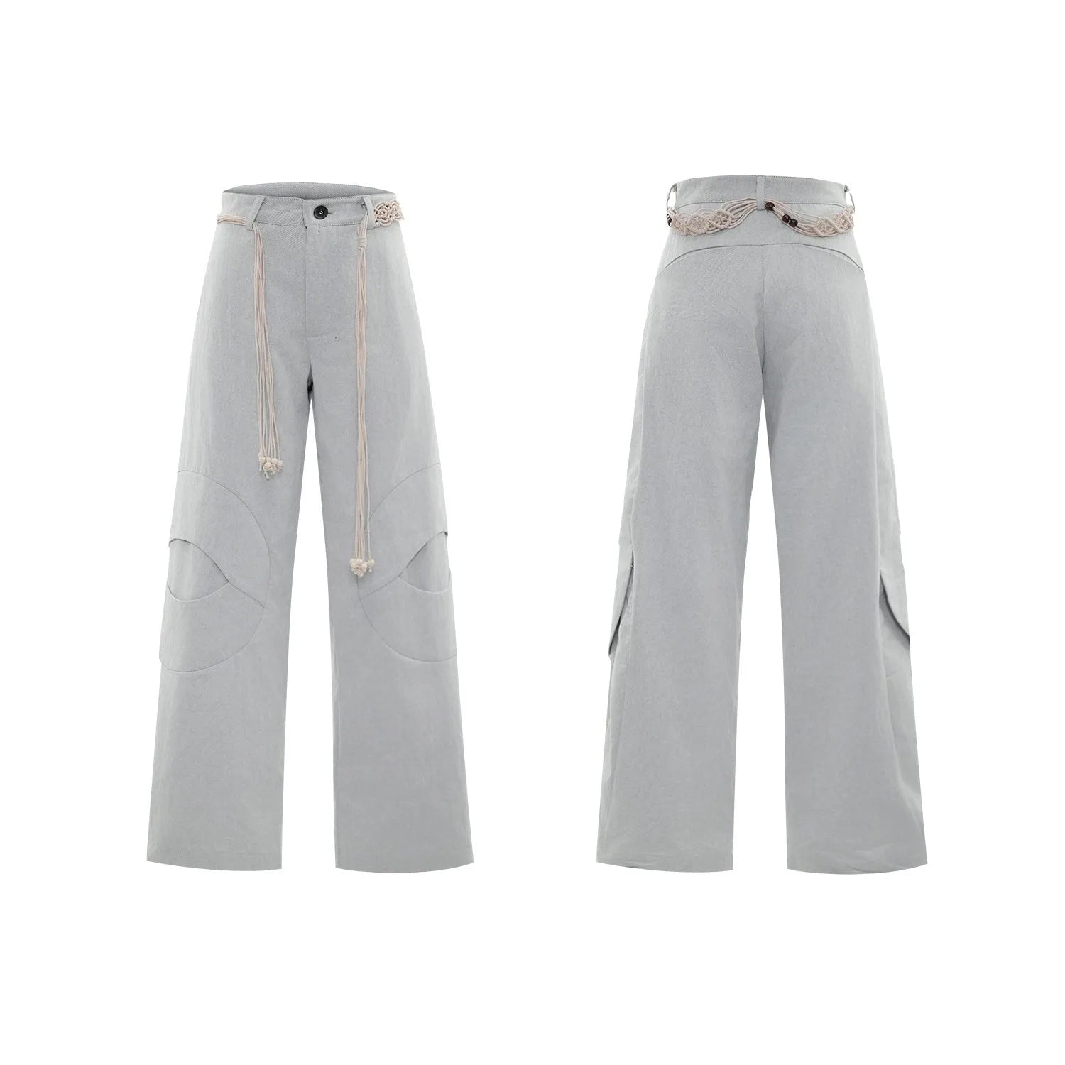 Man wearing dark blue cotton straight-leg trousers with heavy 3D belt stitching and decorative tassel details.