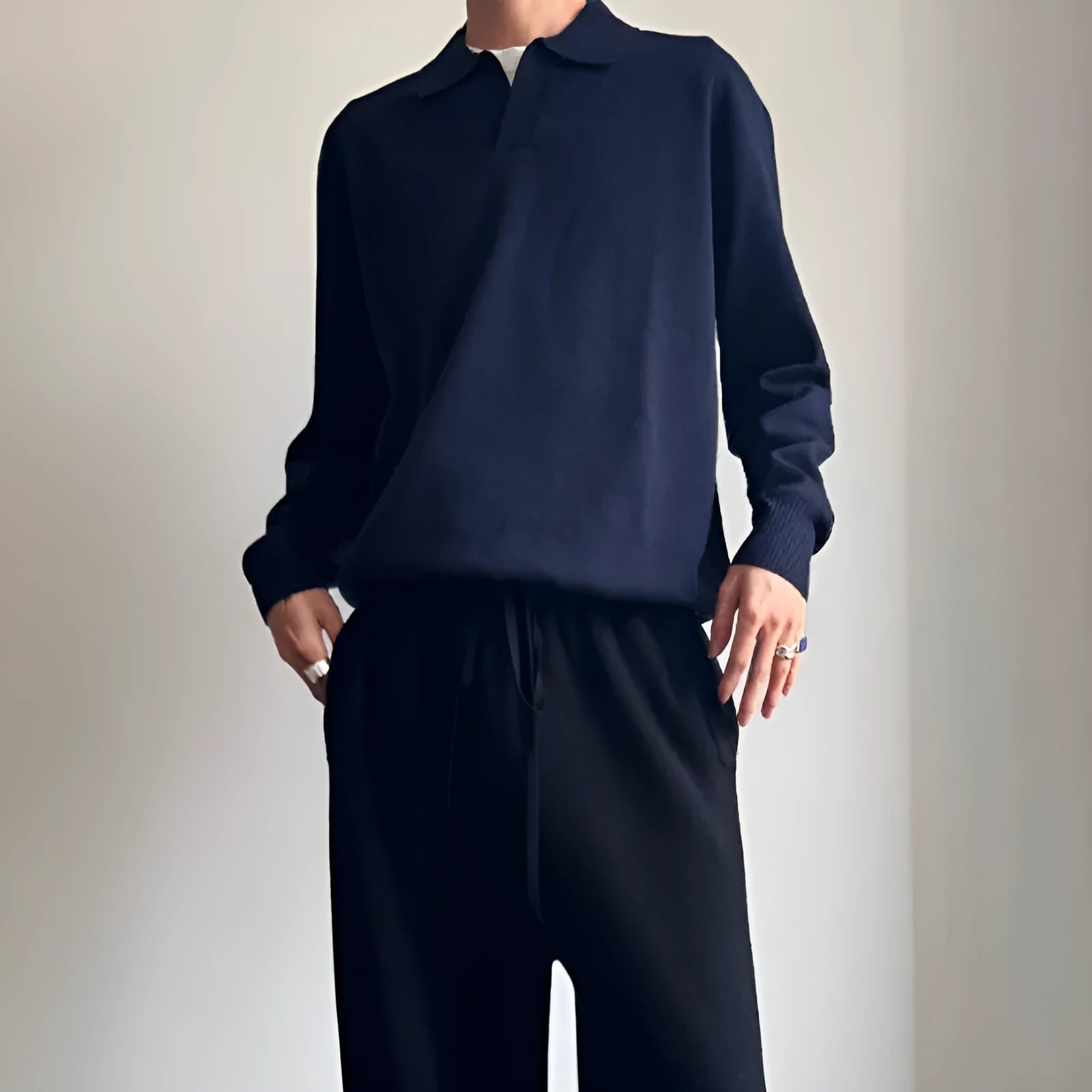 Pure wool polo sweater with lapel collar in navy blue on a hanger.
