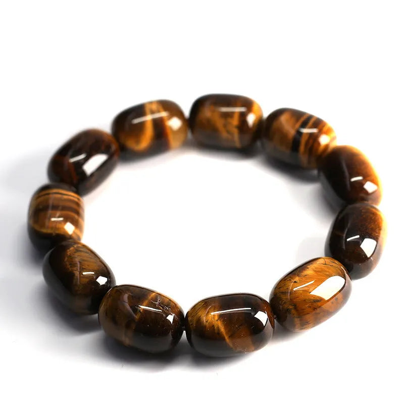 Natural yellow tigereye gemstone bracelet with ethnic constellation design on a wrist.