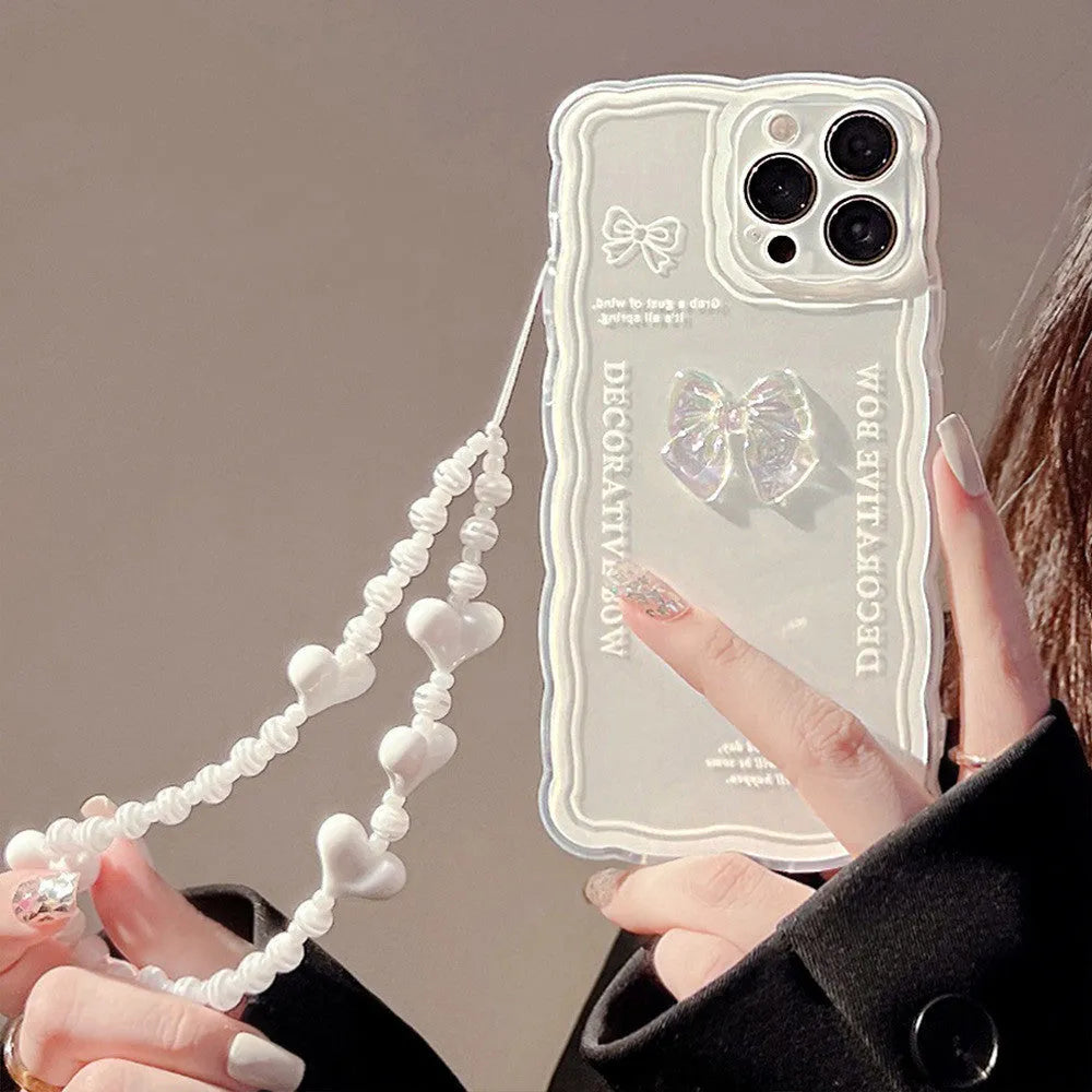 Clear iPhone case with a raised 3D ice bow design and a white love lanyard attached.