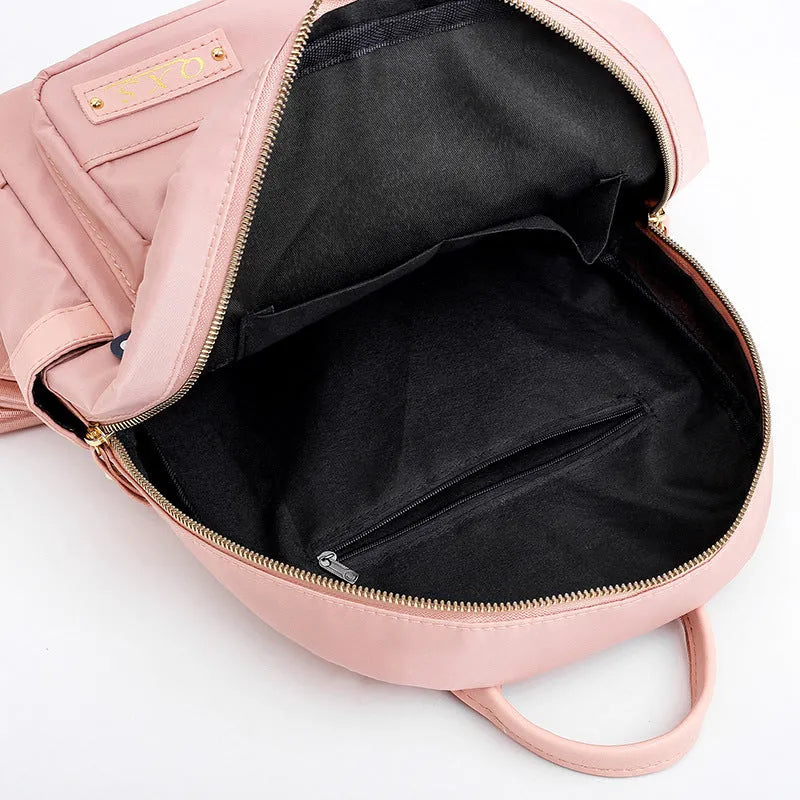 Black and pink casual nylon backpack with double straps, soft handle, and external pocket.