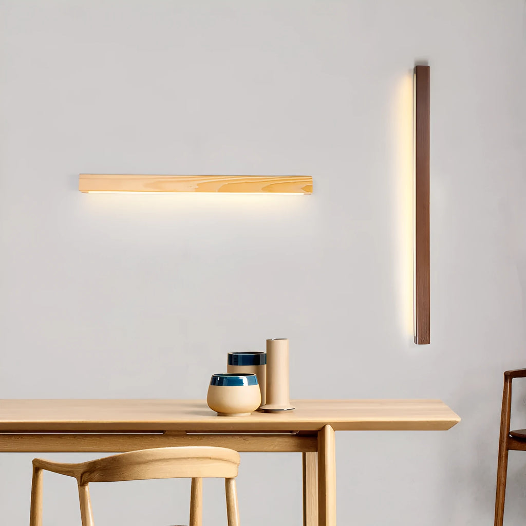 Walnut colour long wooden strip wall lamp with integrated LED lighting mounted on a wall.
