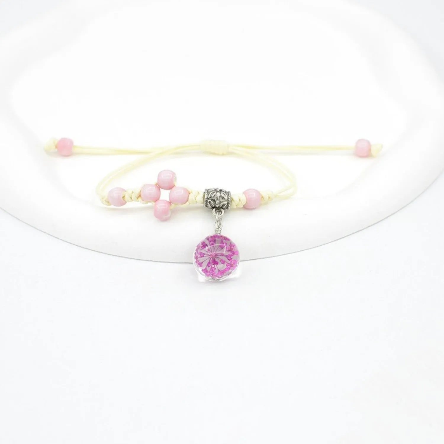 Hand-woven glass bracelet with large beads containing real dried flowers, shown in multiple colour options.