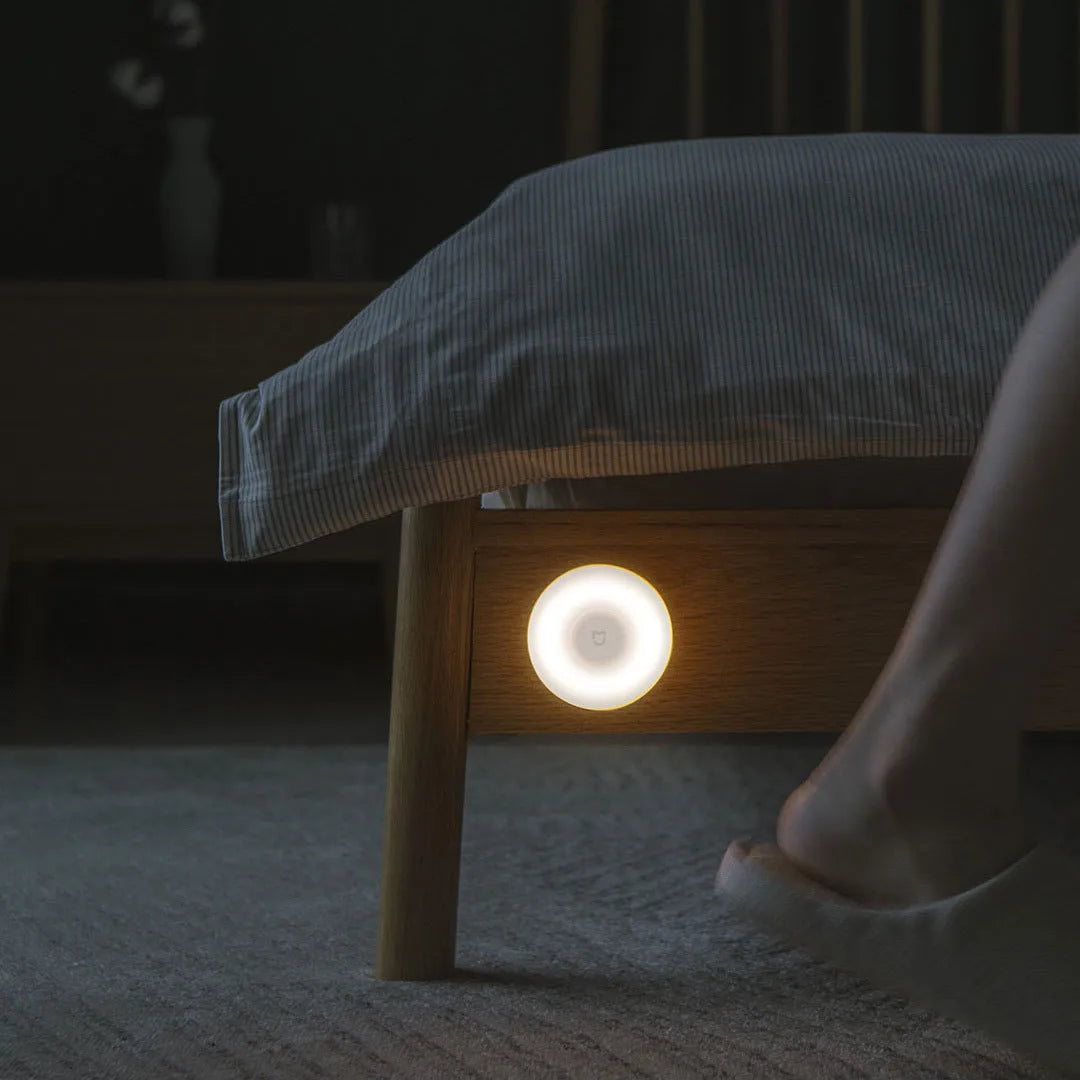 White modern bedside table lamp with human body induction and Bluetooth, shown on a nightstand.