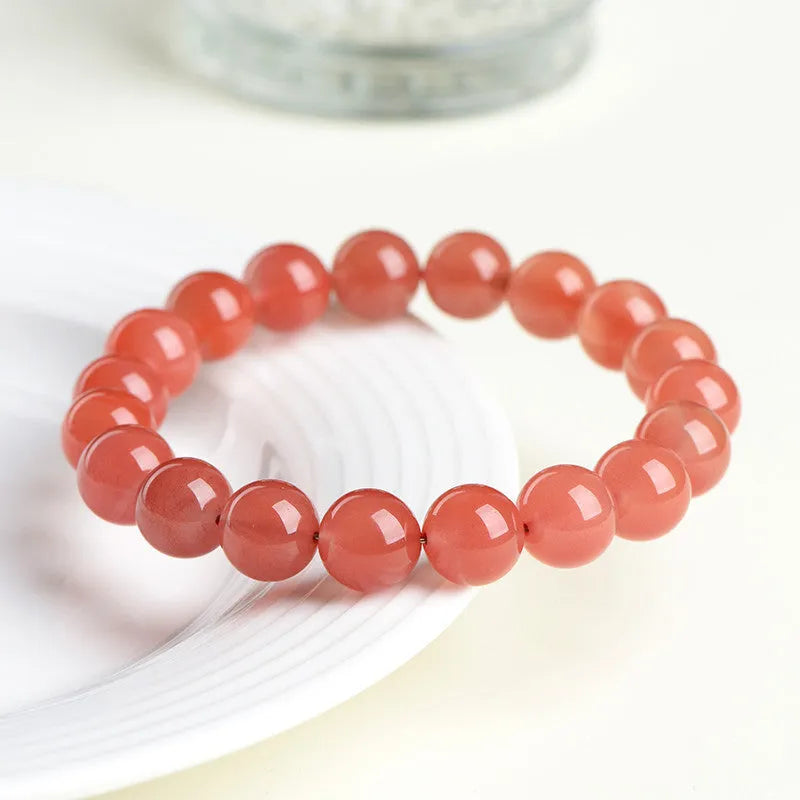 Natural cherry red agate beaded bracelet shown in a single loop, with polished round stones.