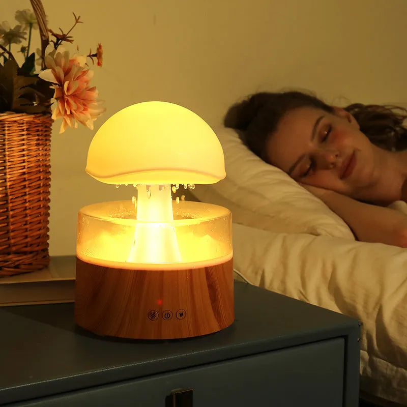 White cloud-shaped ultrasonic aroma diffuser and humidifier with simulated raindrops and coloured lights.