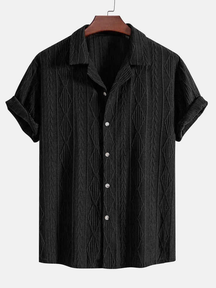 Man wearing a loose black cotton-linen blend casual cardigan shirt on a beach.