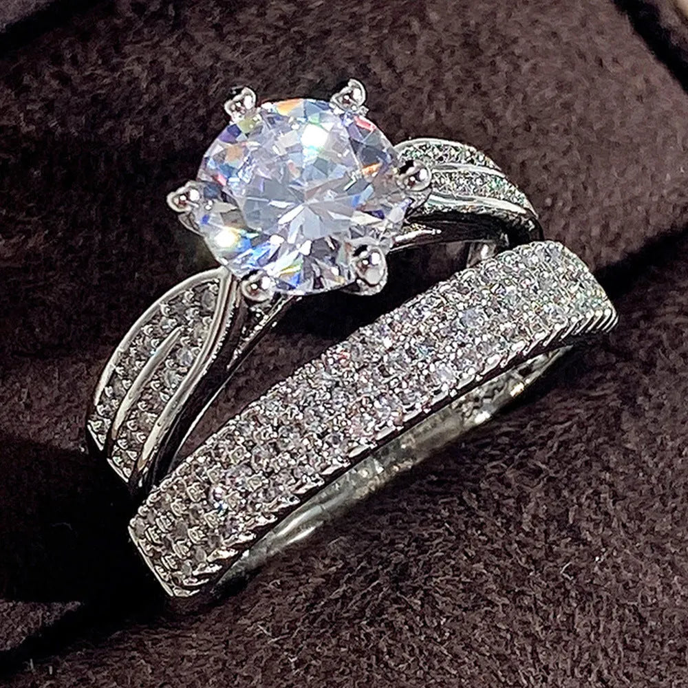 White gold colour geometric wedding ring bracelet on a finger, showing combined ring and band design.