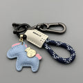 Handmade brown cowhide leather key ring with a zinc alloy pendant charm on a green flannel rope.