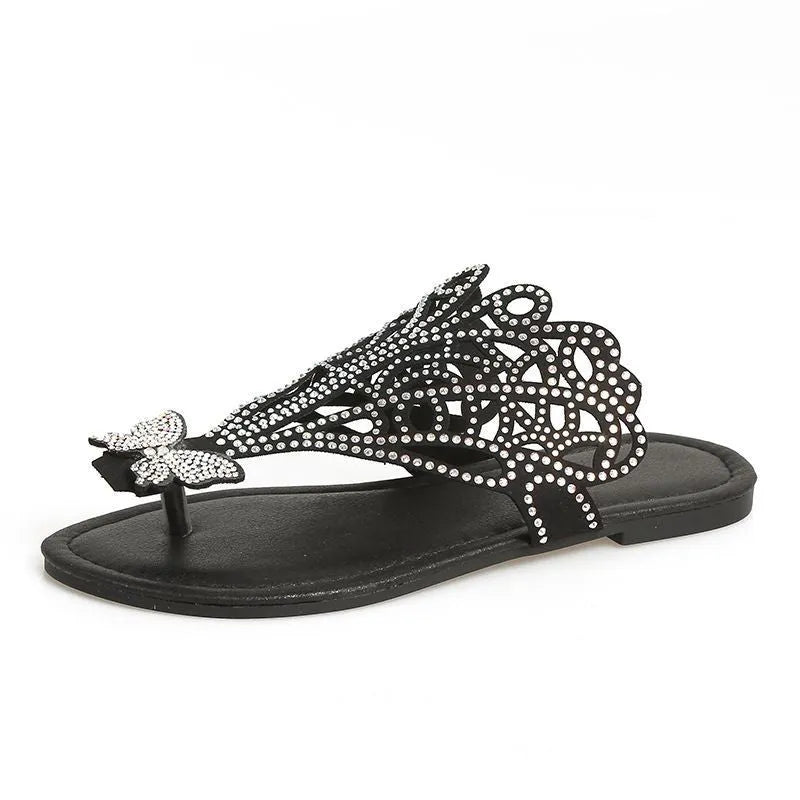 Women's black slip-on sandals with rhinestone decoration and an open flip-toe design on a flat rubber sole.