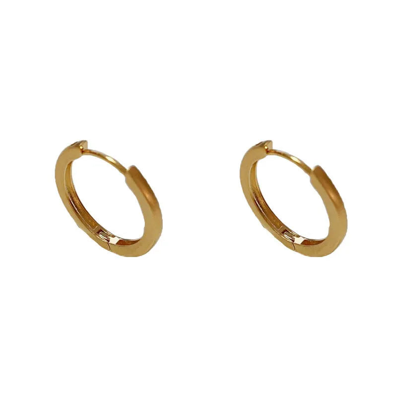 Geometric round women's ear clip with eyelet detail in gold or silver finish