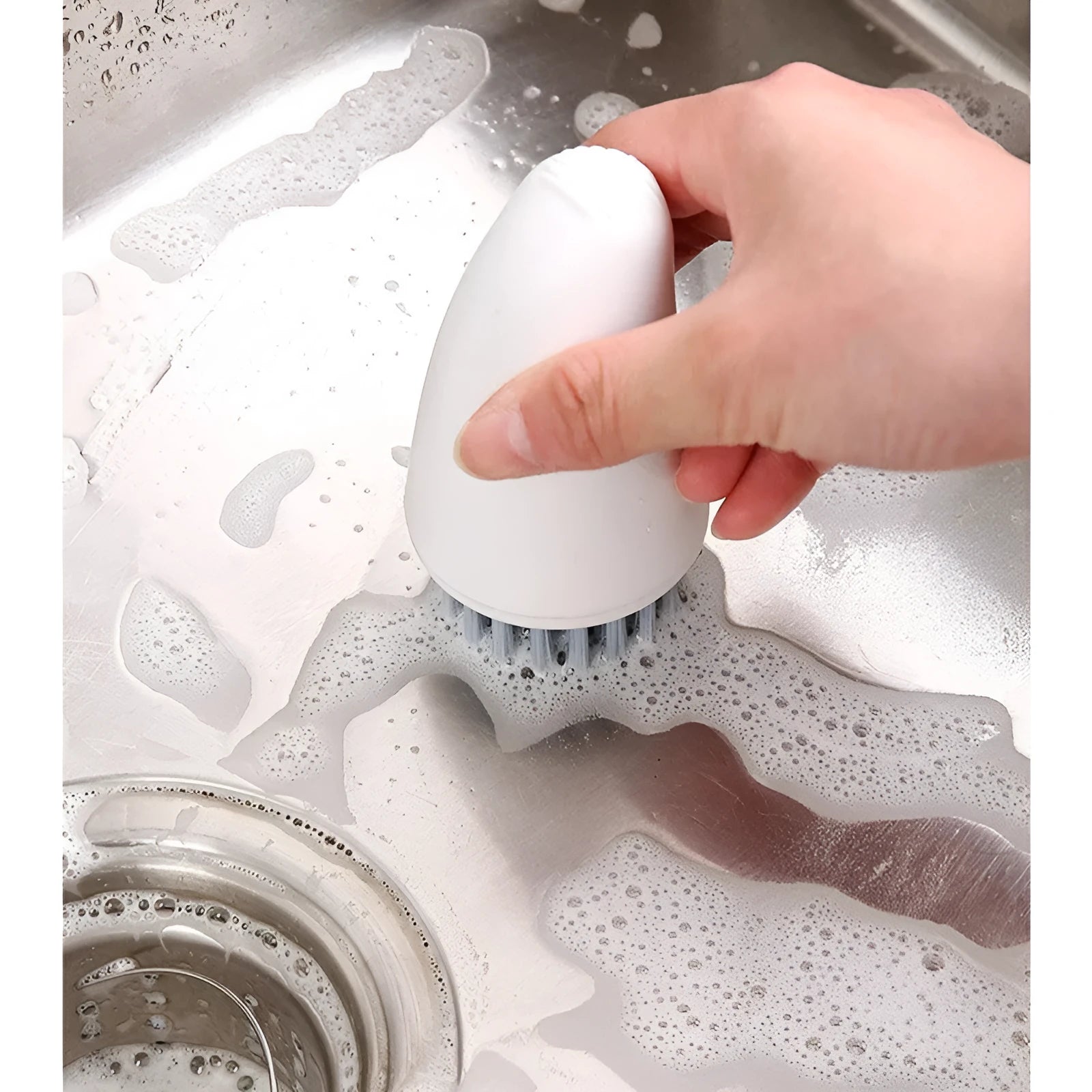 Orange and white carrot-shaped nylon kitchen cleaning brush on a plain background.