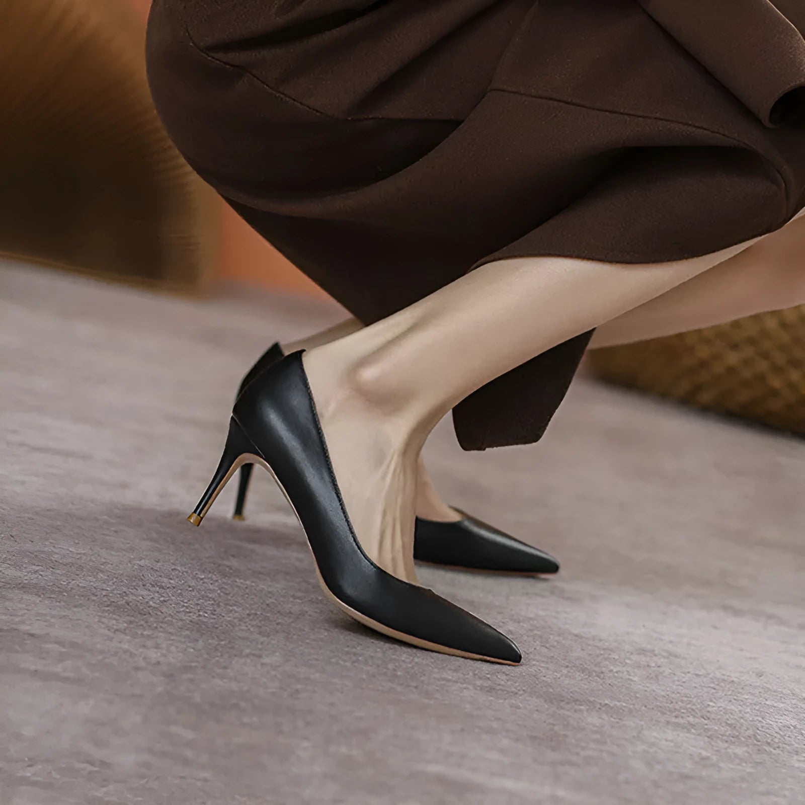 Black pointed-toe high heel pump with a stiletto heel on a plain background.