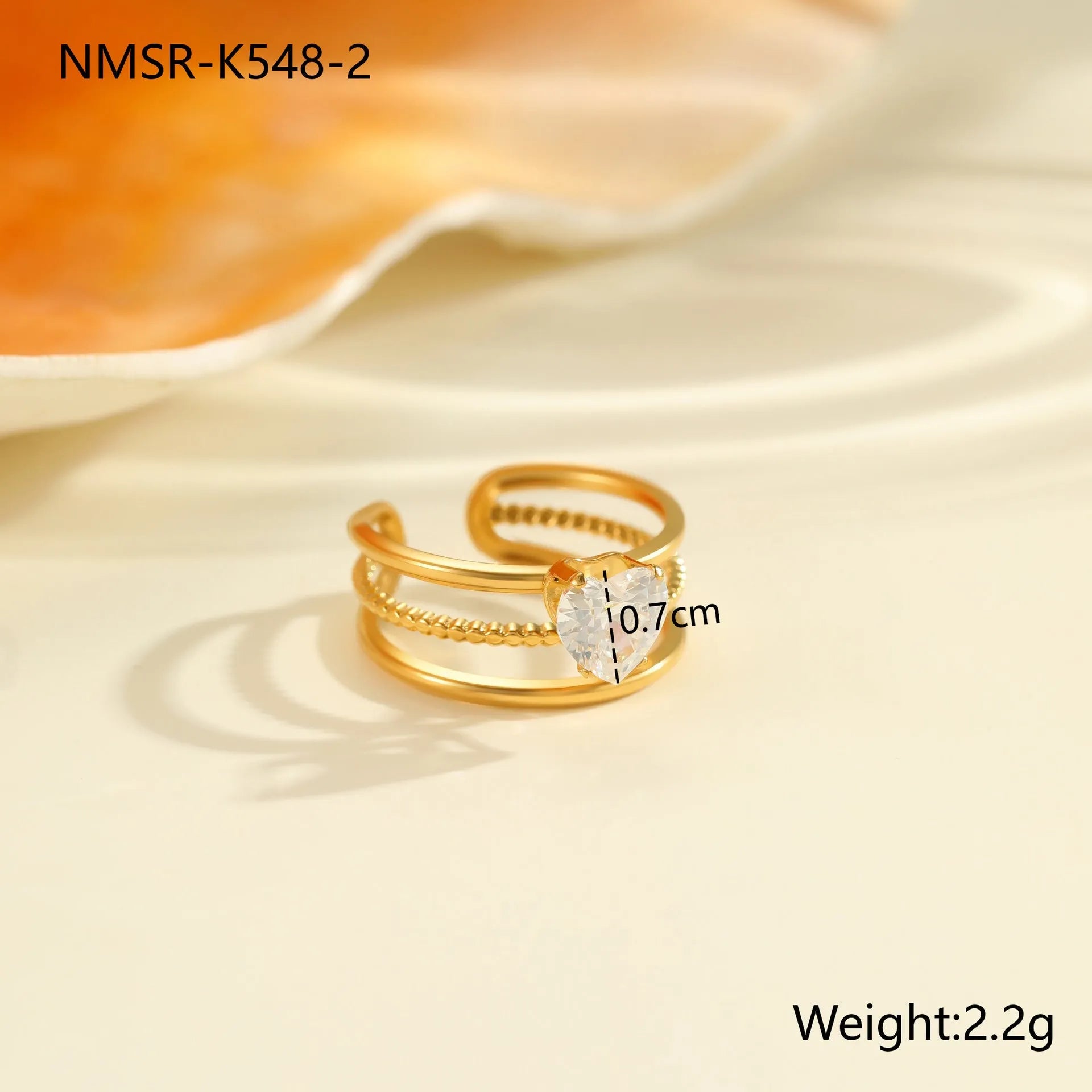 Gold electroplated adjustable ring with geometric zircon design on a stainless steel band.
