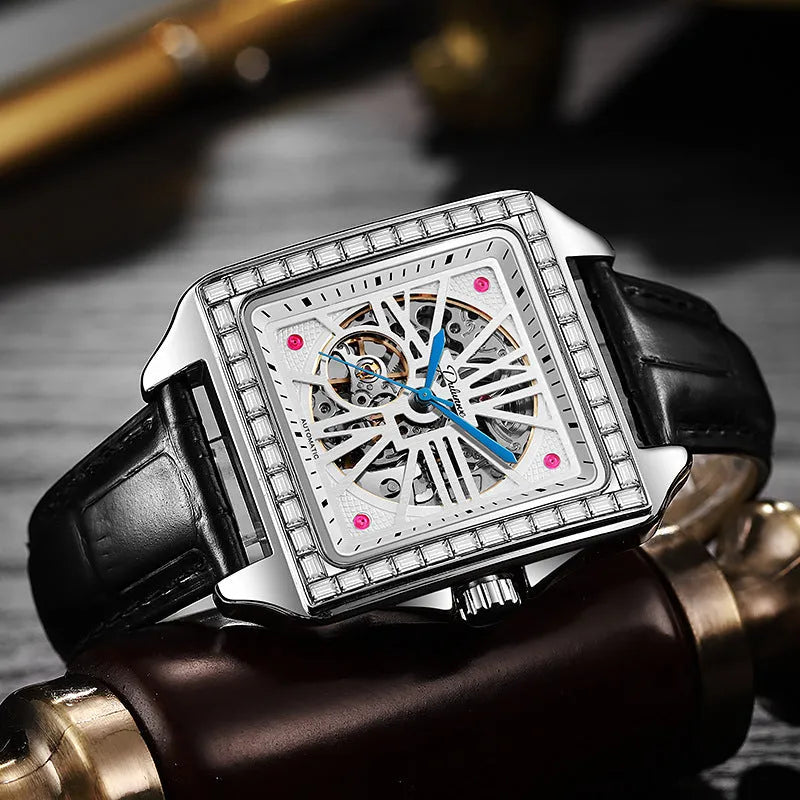 Men's square-faced automatic watch with diamond studs on a stainless steel bracelet.