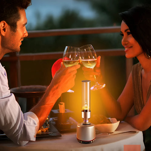 White silver cylindrical Bluetooth speaker and candlelight night light on a table.