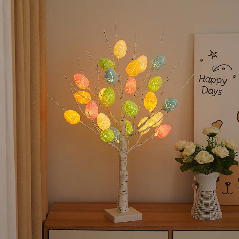 White plastic birch tree Easter decoration with warm white LED lights and hanging coloured eggs on adjustable branches.